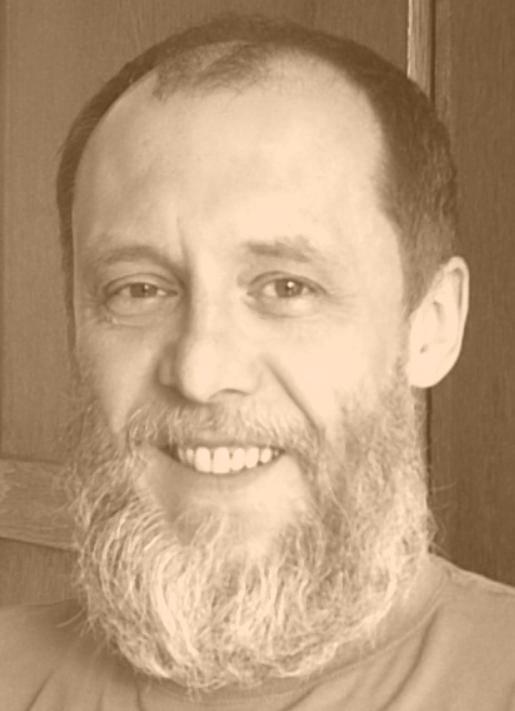 prtret uśmiechniętego mężczyzny z brodą w kolorze sepii